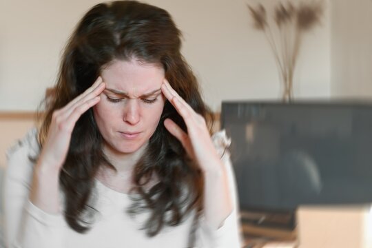 Blured photo of a woman suffering from vertigo or dizziness or other health problem of brain or inner ear.