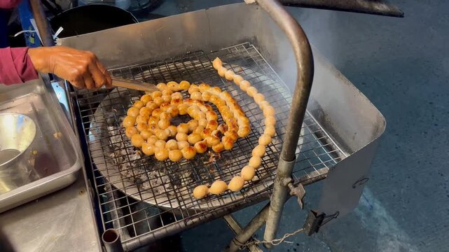 Grilled Thai Isan sausage (Sai Krok Isan) on charcoal grill, Thai street food