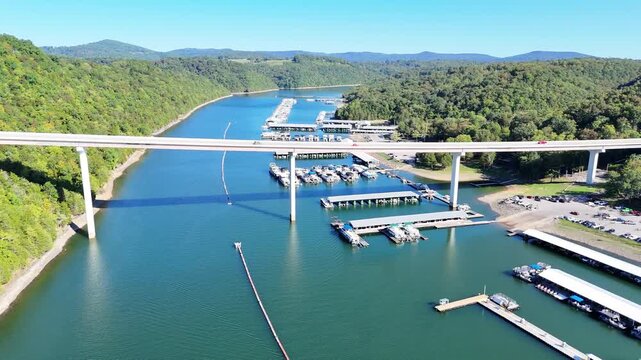 Aerial View of the Lakeside Sunset Marina Resort on Dale Hollow Lake With Highway 111 Bridge, Boats and Forested Shoreline, Calm Water on a Sunny Day, Monroe, Tennessee, USA.
