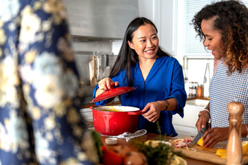Diverse friends cooking together happily.