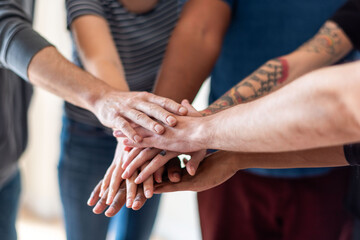 Diverse hands joining together.