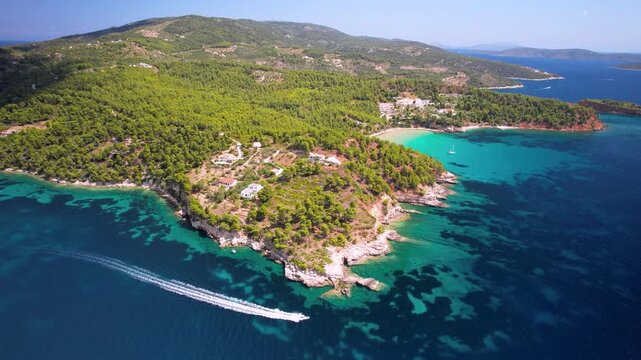 Alonissos speed boat 4k drone of white wake in turquoise sea between Milia and Chrisi Milia. Aerial action of motor boat near rocky cliffs in Greece. Rent boats Greece travel b-roll