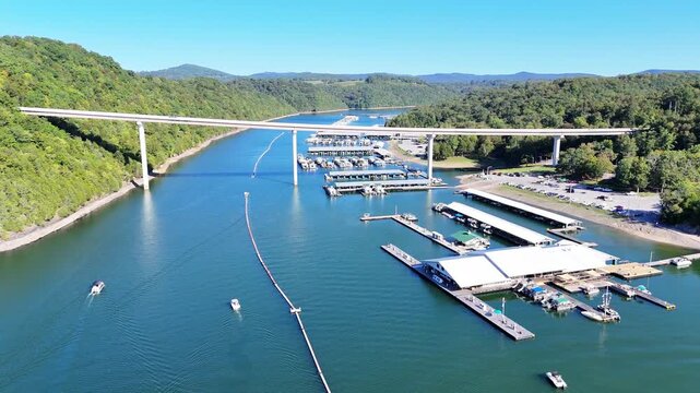 Aerial View of the Lakeside Sunset Marina Resort on Dale Hollow Lake With Highway 111 Bridge, Boats and Forested Shoreline, Calm Water on a Sunny Day, Monroe, Tennessee, USA.