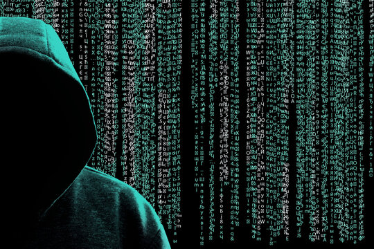 Cyber criminal in hood against programming code