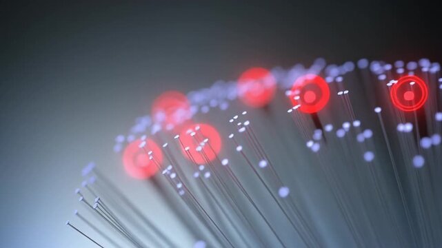 Close-up of fiber optic cables transmitting data with red light pulses in a dark background for technology and communication concepts