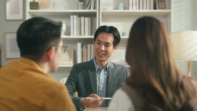 Professional financial advisor presenting investment and savings strategy to couple with tablet analytics, future wealth planning and personal finance consultation concept.	
