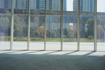 Empty indoor space with glass curtain wall overlooking urban street view and high-rise buildings © zhu difeng