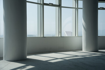Obraz premium Modern office space with white columns and floor-to-ceiling windows allowing natural light