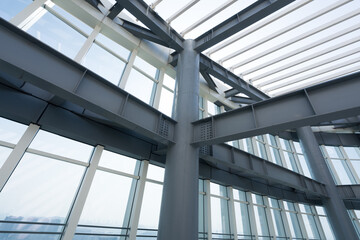 Obraz premium Modern architectural steel structure with glass curtain wall details and geometric framing