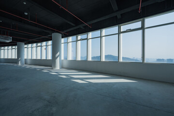 Naklejka premium Spacious office interior with floor-to-ceiling windows allowing abundant natural light