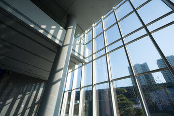Naklejka premium Modern architectural interior with glass curtain wall allowing natural sunlight illumination