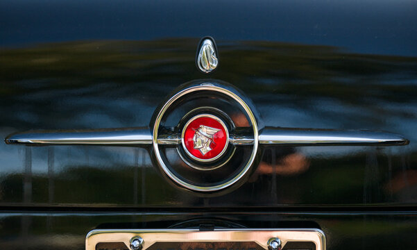 Gothenburg, Sweden - July 25 2024: Close view of vintage car emblem and chrome details on dark glossy surface.