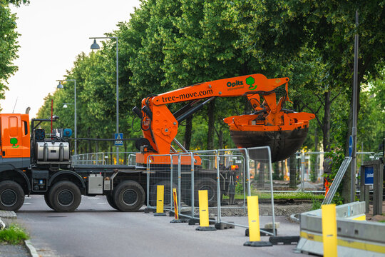 Gothenburg, Sweden - June 26 2024: Large tree transplanter machinery operating on city street during urban landscaping project.
