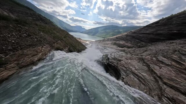 Dynamic FPV Drone Dive Over Powerful Waterfall and Glcial Lake