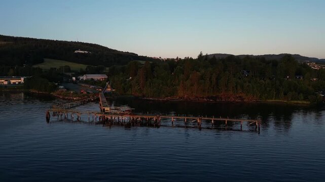 Aerial View of Abandoned Woden Pier in Calm Lake Durig Golden Hour