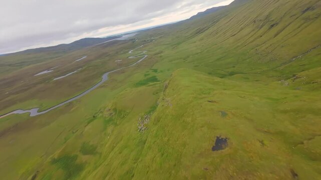 Aerial View of Winding River in a Vast Green MountainValley