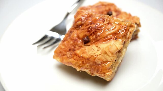 closeup of baklava pastry dessert on white dish