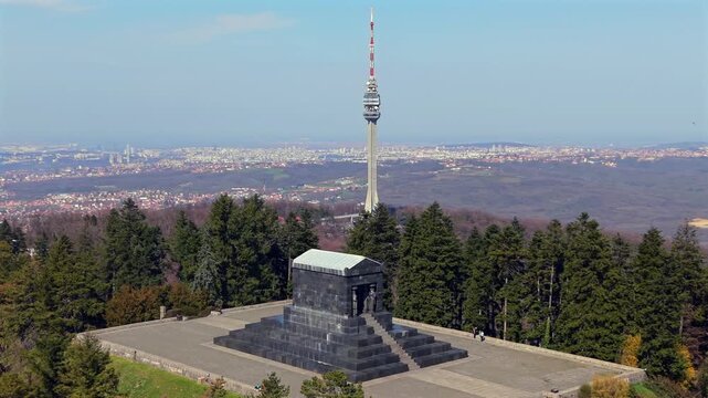 Aerial drone circular shot of the Monument to the Unknown Hero and the telecommunication tower in the distance, Belgrade, Serbia.