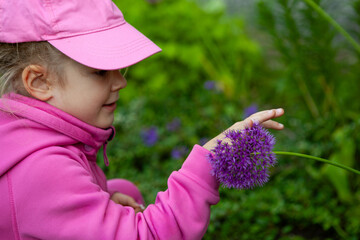 Cute child pointing at purple ornamental flower © Yana Gavriloski