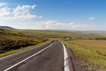 Empty Asphalt Road Through Green Rolling Hills Summer Landscape