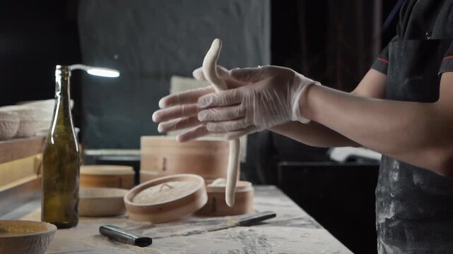chef hands kneading and cutting fresh noodle dough in kitchen