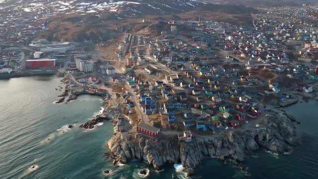 Vibrant homes line the coastline of a remarkable Greenland town, showcasing a stunning blend of nature and culture.