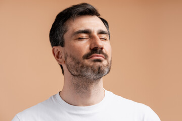 Obraz premium Man with eyes closed, experiencing tranquility and mindfulness