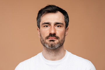 Obraz premium Mature man with beard and neutral expression looking forward, portrait
