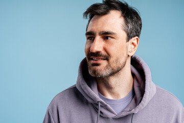 Obraz premium Man in purple hoodie looking away, having an idea or thinking about future