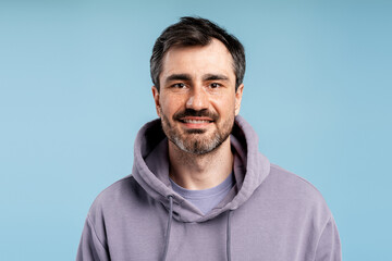 Obraz premium Handsome natural man smiling, looking at camera in a casual hoodie