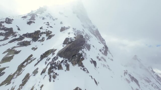 Cinematic Aerial View of a Rugged Rocky Mountain PeakShrouded in Mist