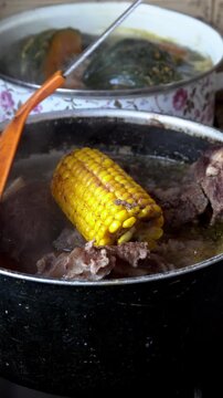 Stirring traditional argentine puchero stew with beef and vegetables, 4K vertical