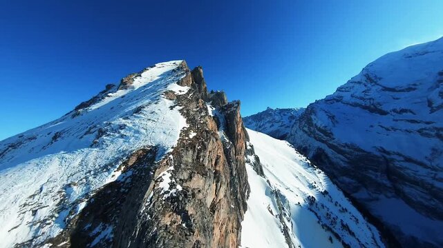 Epic Aerial Close up of Snowy Mountain Peak and Jagge Rock Formations in the Als