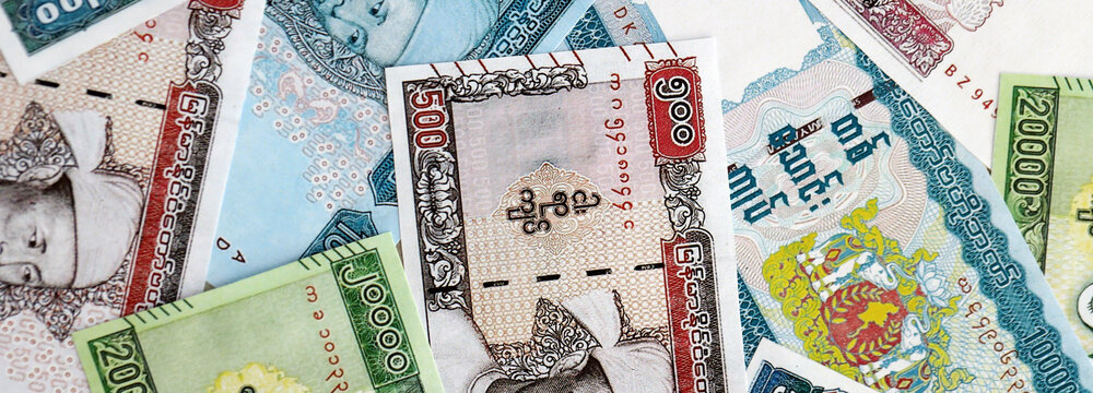 Myanmar kyat paper banknotes pile on table. Myanmar MMK currency money bills in big amount. Concept of economics, taxation and banking in Myanmar