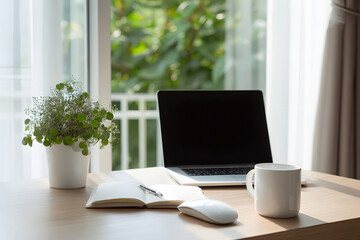 Workspace with laptop, notebook, and cup near window in a home setting during daytime