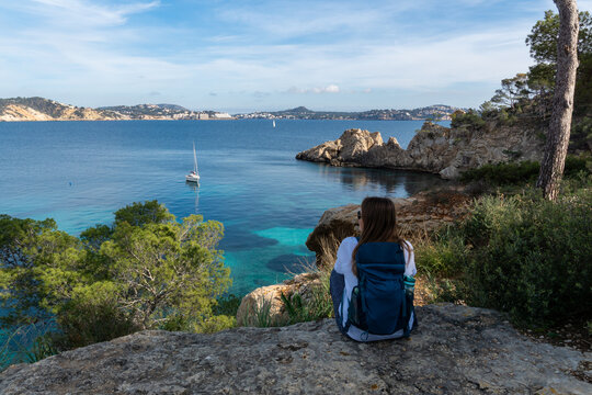 Woman with Backpack Enjoying the Scenic View over Cala Fornells Bay in Mallorca