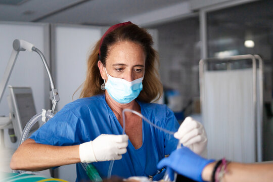 Nurse wearing mask and gloves preparing medical equipment