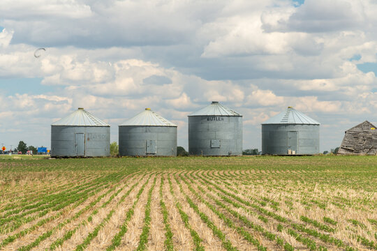 Canada, Saskatchewan, Regina.  A line of steel storage bins and equipment sheds along the horizon in the great plains of the Canadian prairies.