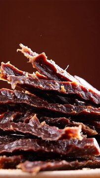 Pile of dried beef jerky strips with fibrous texture representing salty protein snack
