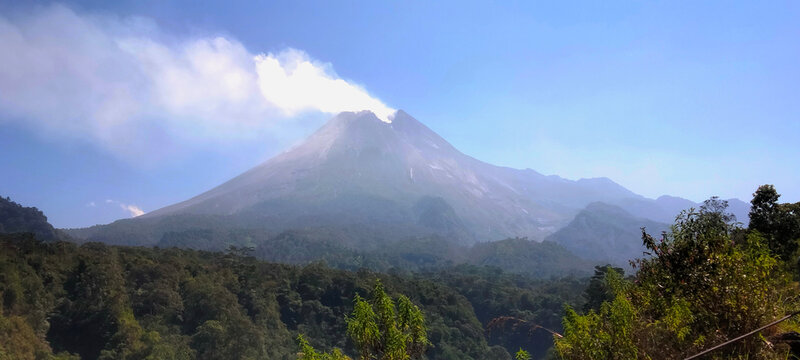 Active Mount Merapi Volcano with Smoke Plume under Blue Sky, Yogyakarta, Indonesia 