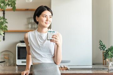 A young Asian woman in sportswear is shown consuming a jelly drink and nutritional supplement jelly.