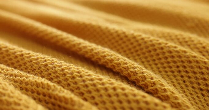 Yellow knitted plaid as background, closeup view