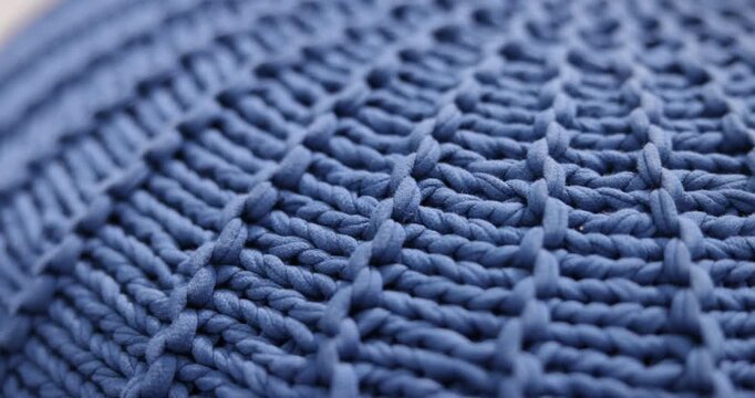 Beautiful knitted blue cushion as background, closeup