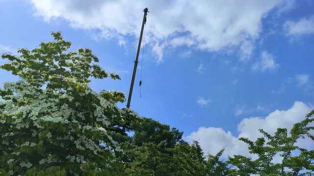 青空の下で作動するクレーン車の作業風景