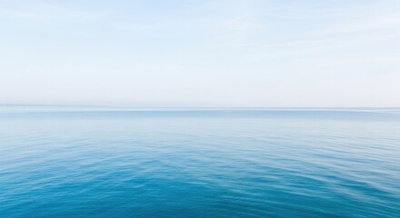 Fototapeta premium Endless calm expanse of a sapphire ocean meeting a pale sky at the distant horizon