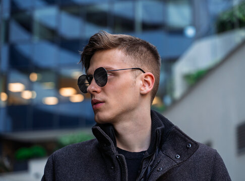 Fashion side view portrait of handsome blonde young guy with sunglasses 