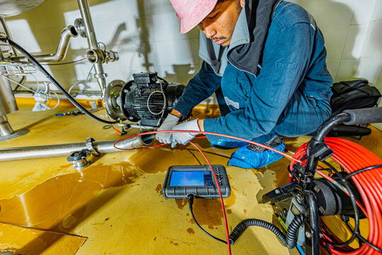 A man starts using a weld pipe stainless inspection camera. The light monitor shows images from the camera head