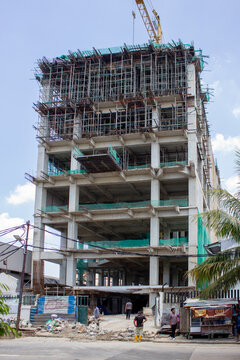 Jakarta, Indonesia - March 16 2026: Construction of a high-rise building with concrete structure and metal scaffolding and a heavy crane on top.