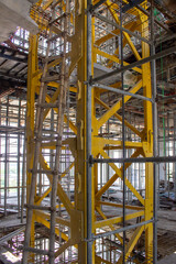 Jakarta, Indonesia - March 16, 2026: Yellow iron emergency staircase or material hoist tower structure in a high-rise building construction project
