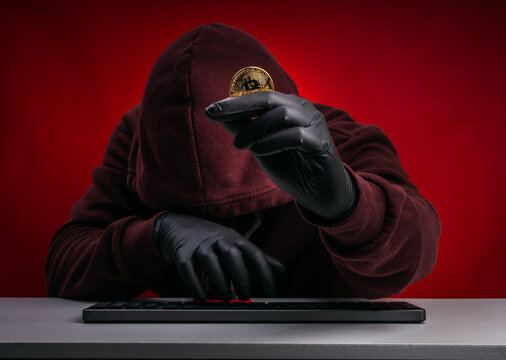 Crypto scam concept showing anonymous hacker stealing Bitcoin through phishing and fake investment schemes. Cybercriminal targeting digital assets with fraud, impersonation and high return promises.